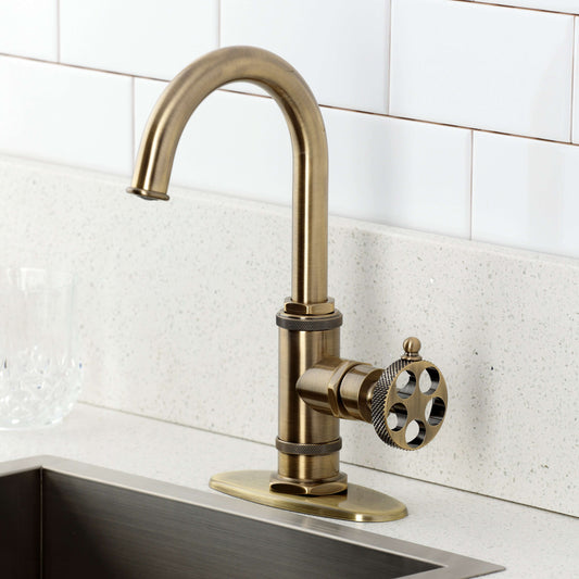Kingston Brass KSD8503RKX Webb Single-Handle Bar Faucet with Knurled Handle, Antique Brass on a kitchen sink.