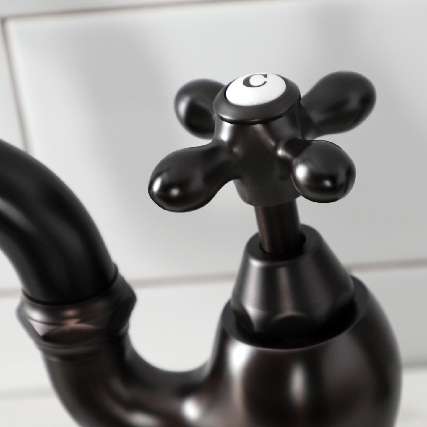 Close-up of the handle of Kingston Brass English Country Deck Mount Bridge Kitchen Faucet, showcasing traditional design.