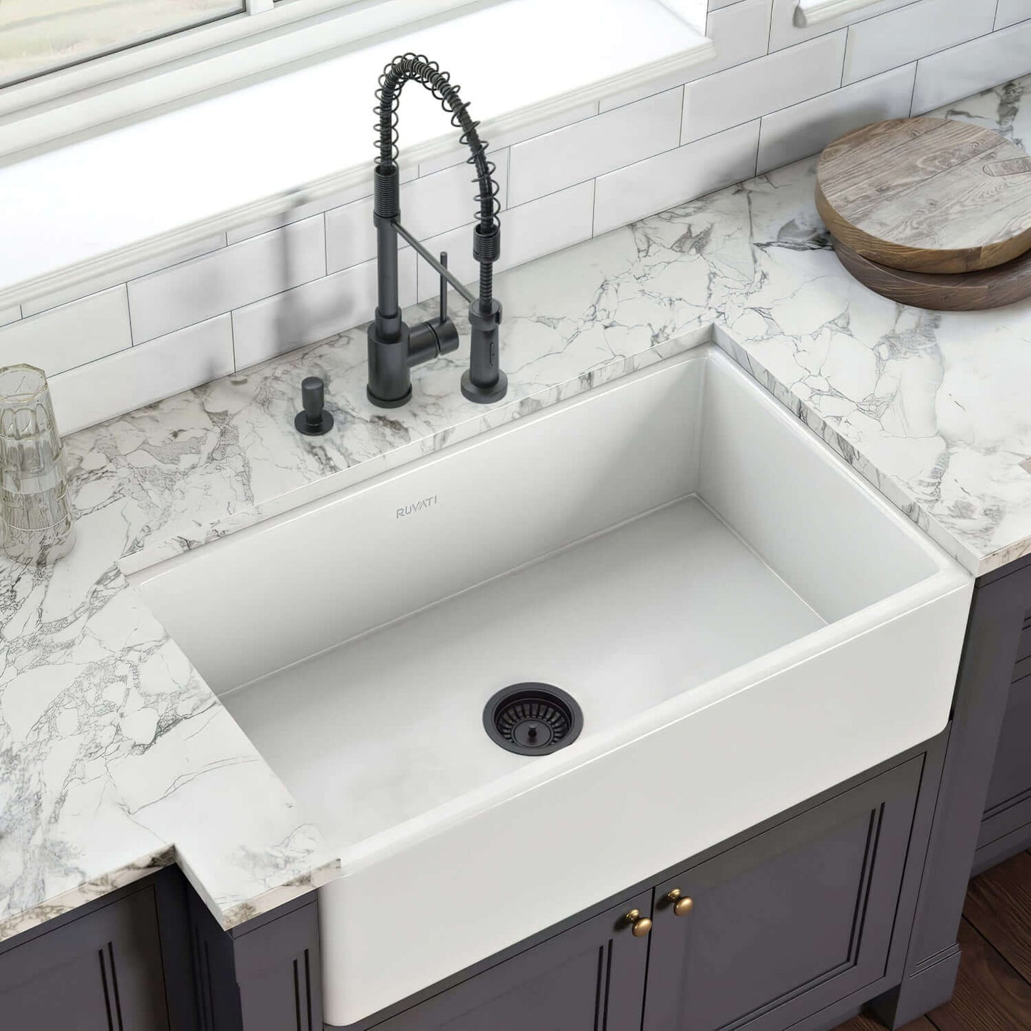 White kitchen sink with black drain strainer in a modern kitchen setting