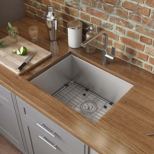 Ruvati 23" Nesta Zero Radius Bar Prep Sink Undermount - RVH7100 showcased in a wooden kitchen countertop with stylish accessories.