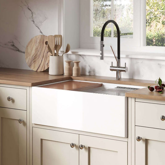 Ruvati 30" Fireclay Workstation Farmhouse Kitchen Sink White - RVL2182WH installed in modern kitchen with utensils.