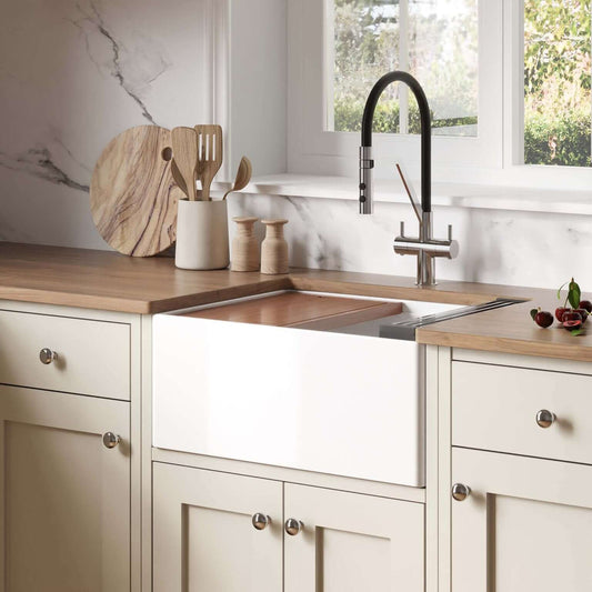 Ruvati 24" Fireclay Workstation Farmhouse Kitchen Sink White - RVL2484WH displayed in a modern kitchen setup with wooden countertops.