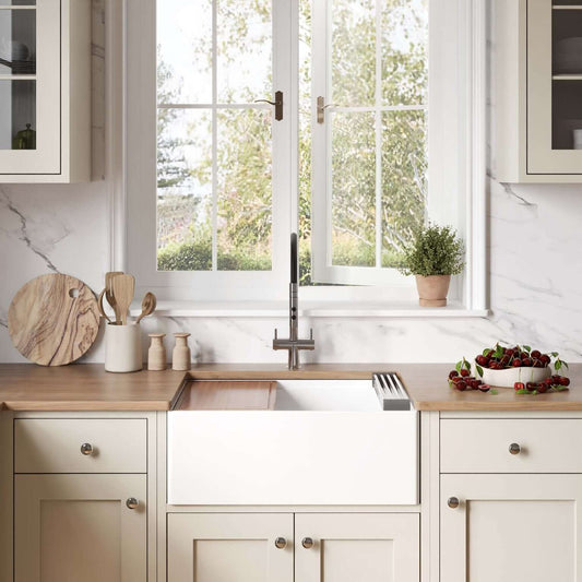Ruvati 27" Fireclay Workstation Farmhouse Kitchen Sink White - RVL2781WH in a modern kitchen setting with natural light.