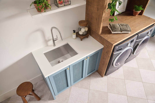 Ruvati 23" Deep Laundry Utility Sink Undermount - RVU6100 installed in a modern laundry room with blue cabinet.