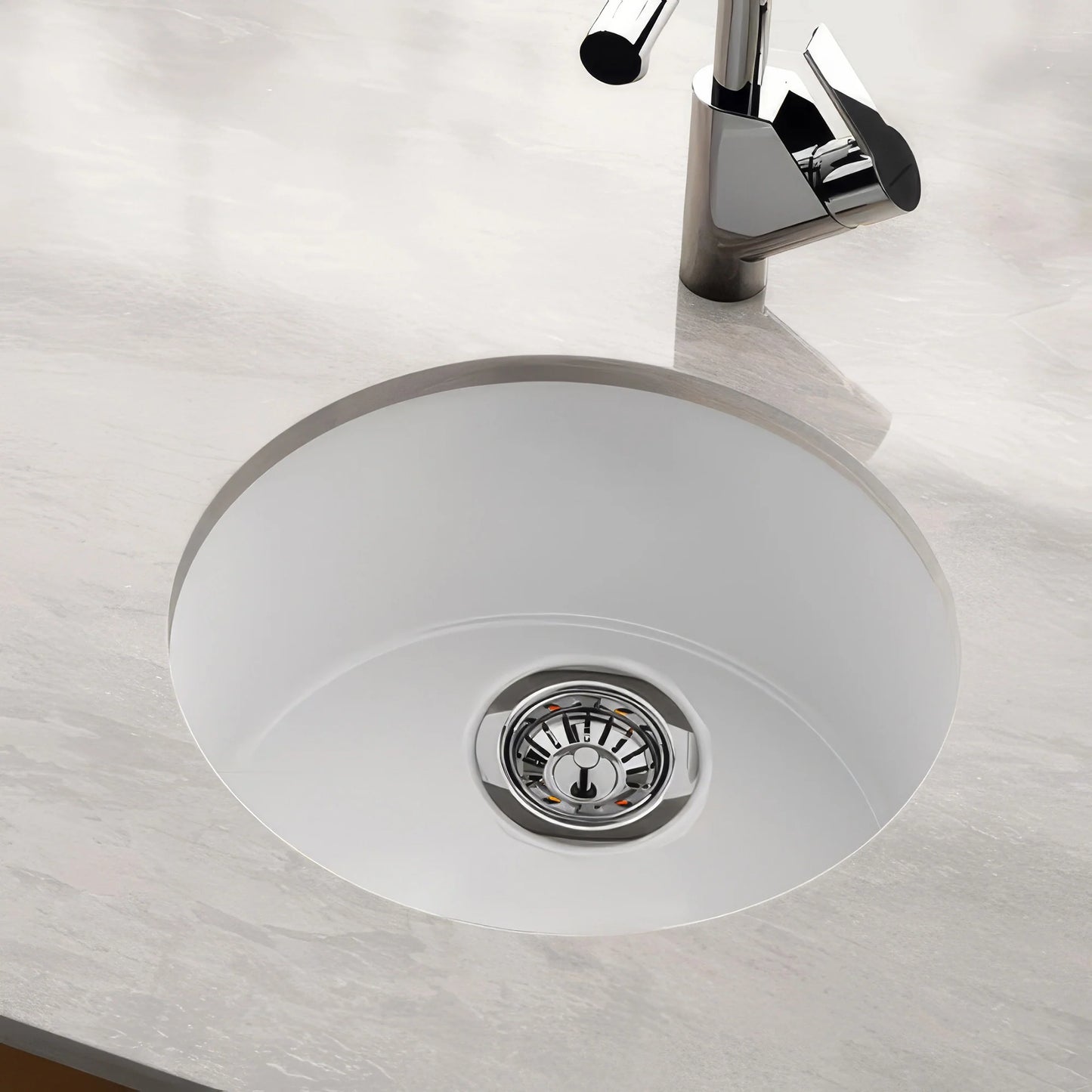 WHITEHAUS 18.25" Elementhaus Fireclay Circular Drop In/Undermount Sink with 3 ½" Rear Center Drain WHE1818R on a countertop.