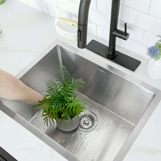 Close-up view of a Stylish Azuni 22" Stainless Steel Dual Mount Utility Sink with a hand washing a potted plant.