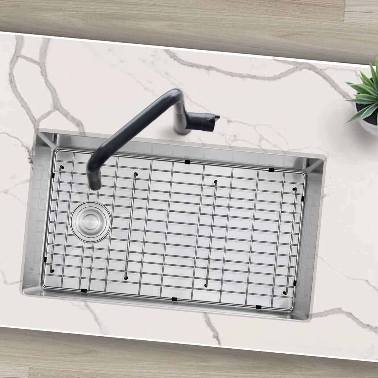 Stylish Azuni 28" Stainless Steel Undermount Kitchen Sink viewed from above, featuring a grid and faucet on a marble countertop.