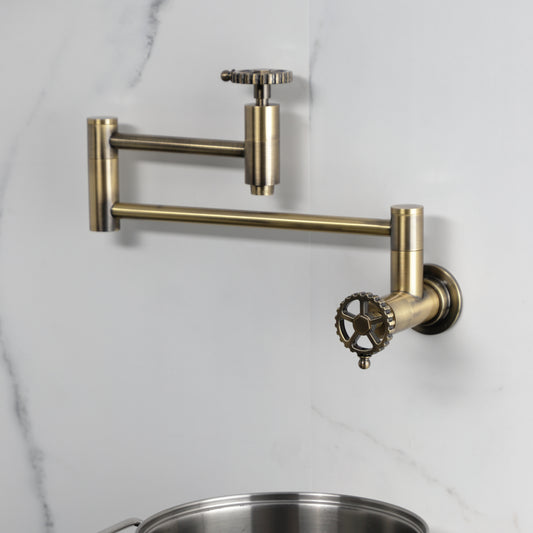 Kingston Brass KS8103CG Fuller Wall Mount Pot Filler Faucet, Antique Brass mounted on a wall with pot below.