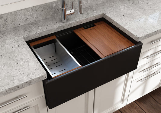 Lifestyle image of a matte black Bocchi Contempo 30" sink in a modern kitchen with colander and cutting board in use.