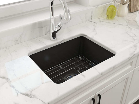 BOCCHI SOTTO 24" Fireclay Dual-Mount Single Bowl Sink with Bottom Grid & Strainer in Matte Black installed on a marble countertop.