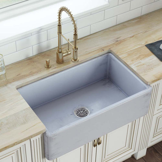 Ruvati Fiamma 33" Reversible Distressed Finish Fireclay Kitchen Sink RVL2300SB with brushed gold faucet and wooden countertop.