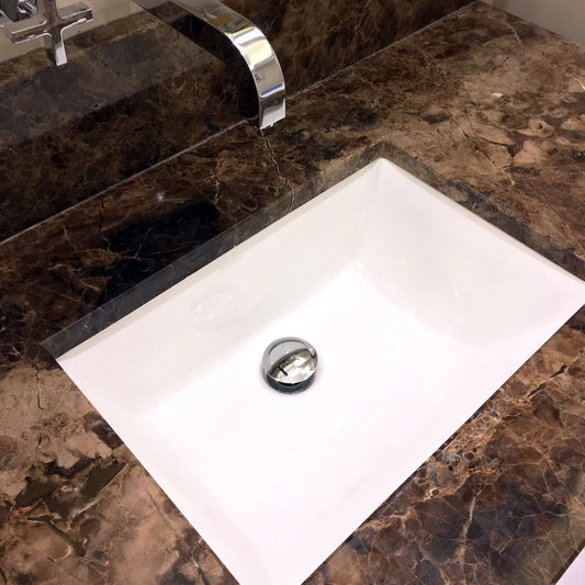 Nantucket 18" Undermount Ceramic Sink UM-18x13-W installed in elegant marble countertop.