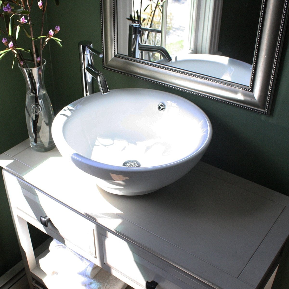 Nantucket Round White Vessel Sink With Overflow - NSV218 displayed on a stylish bathroom vanity with flowers.