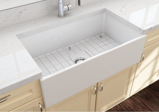 Lifestyle image of the Bocchi Contempo 33" Fireclay Farmhouse Sink in White, showing included stainless steel bottom grid and strainer