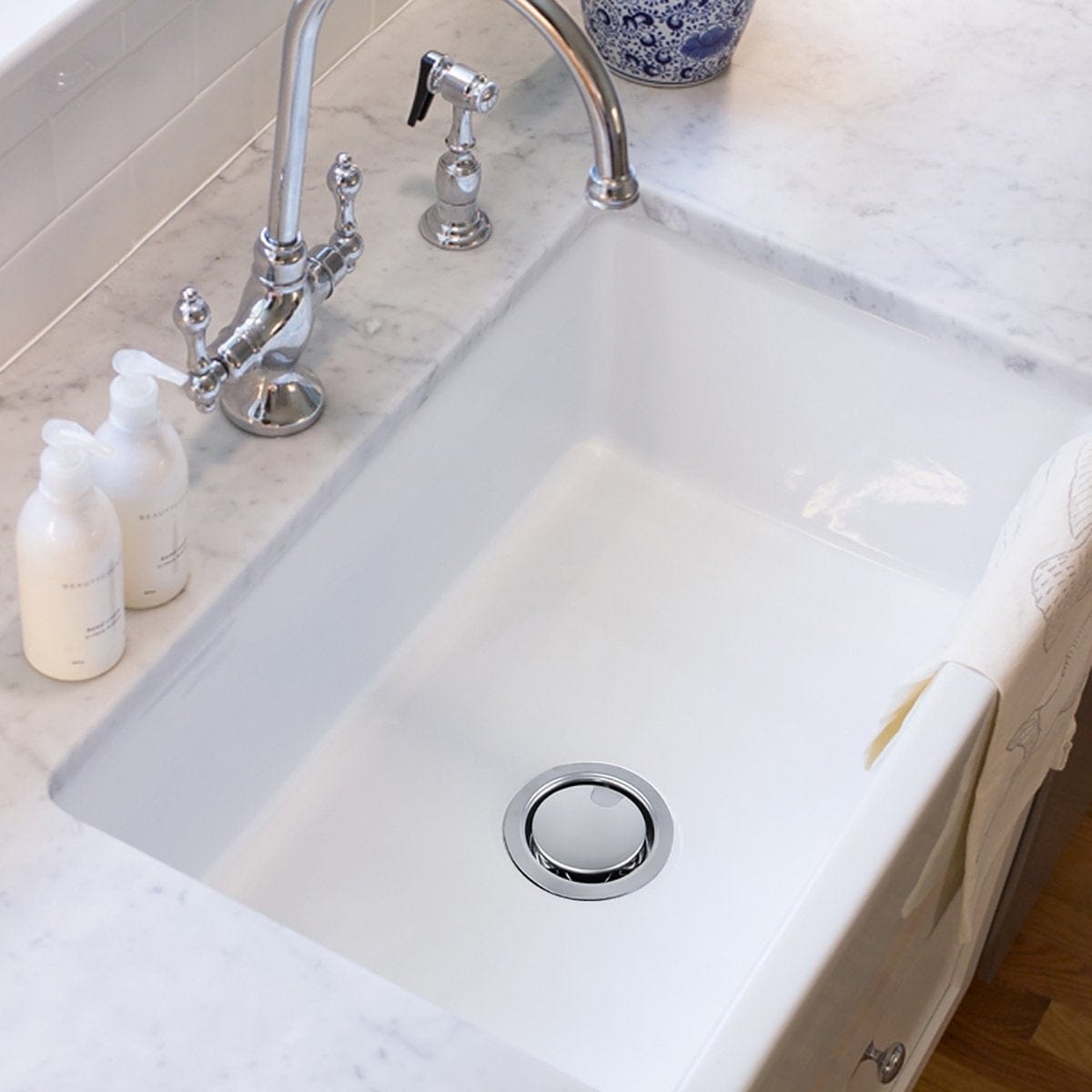 Nantucket Chrome Crumb Cup Disposal Drain Kitchen Drain - NS35LCC-DD mounted in a clean kitchen sink with soap dispensers.