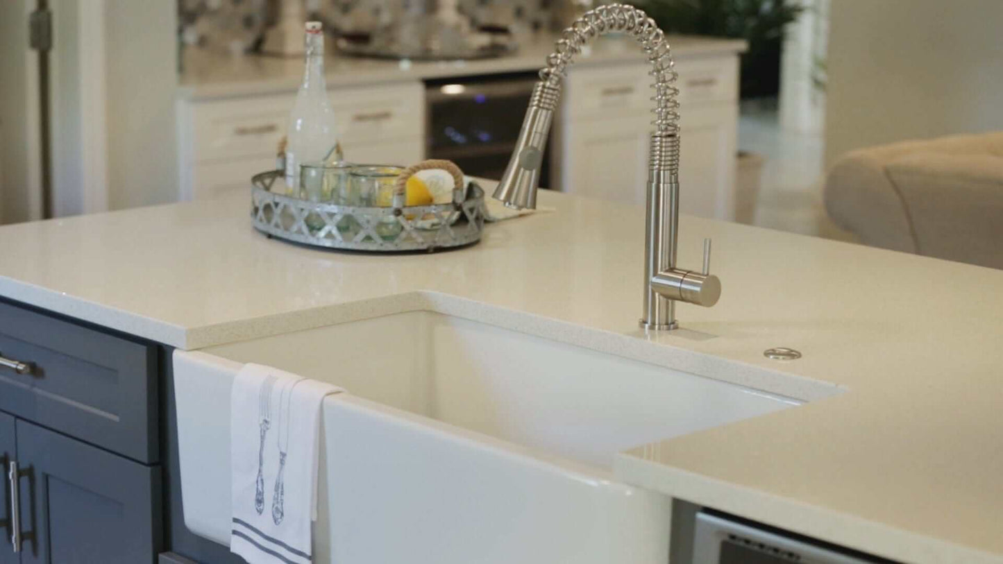 ALFI 33" White Smooth Apron Fireclay Farmhouse Sink in modern kitchen with stylish faucet and decor.
