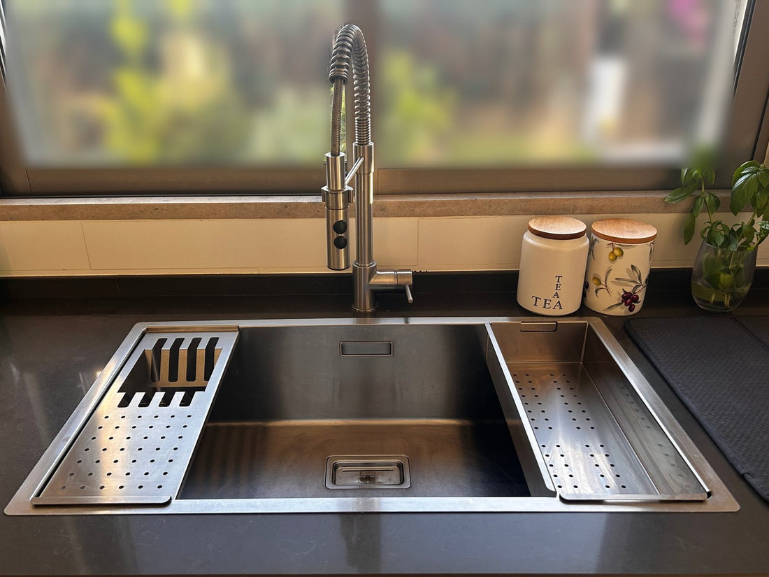 Clare's stainless steel workstation sink with a shallow strainer and deep colander on the ledge