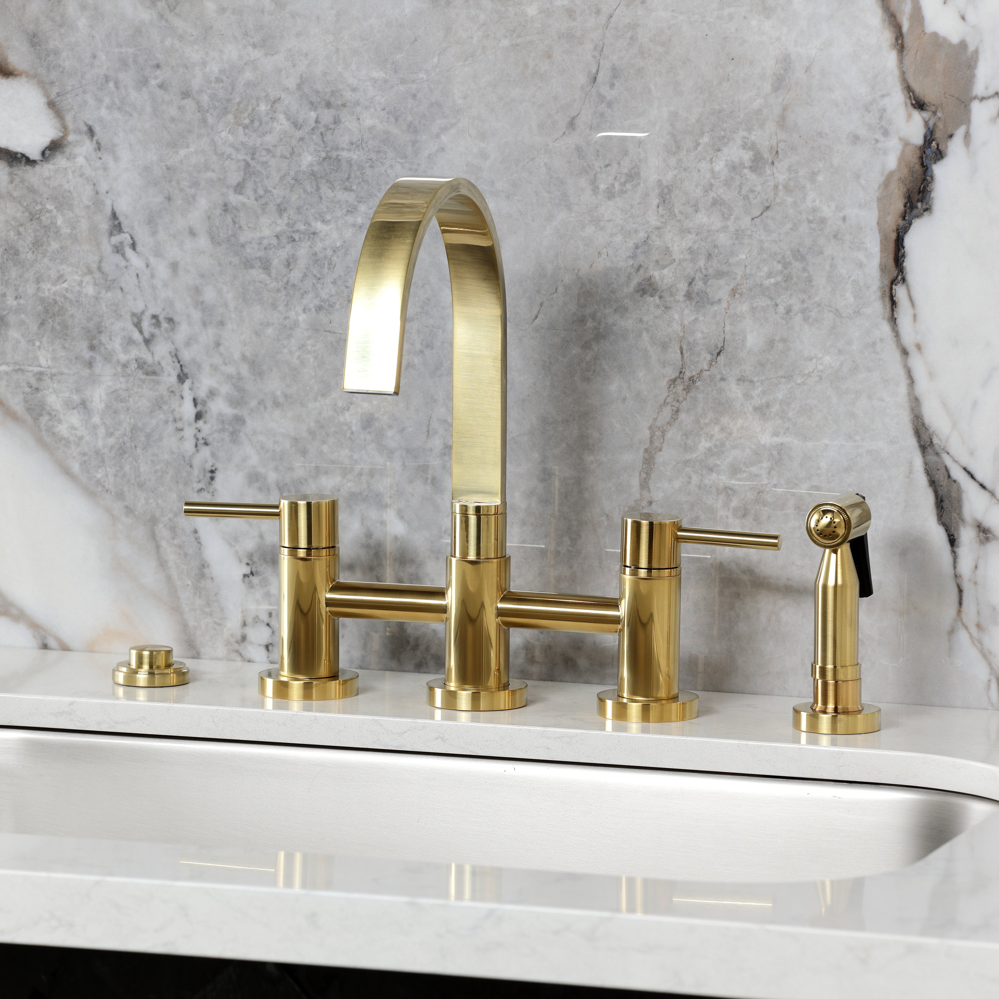 Kingston KS8267DLBS Concord Bridge Kitchen Faucet with Brass Sprayer, Brushed Brass on countertop with marble background.