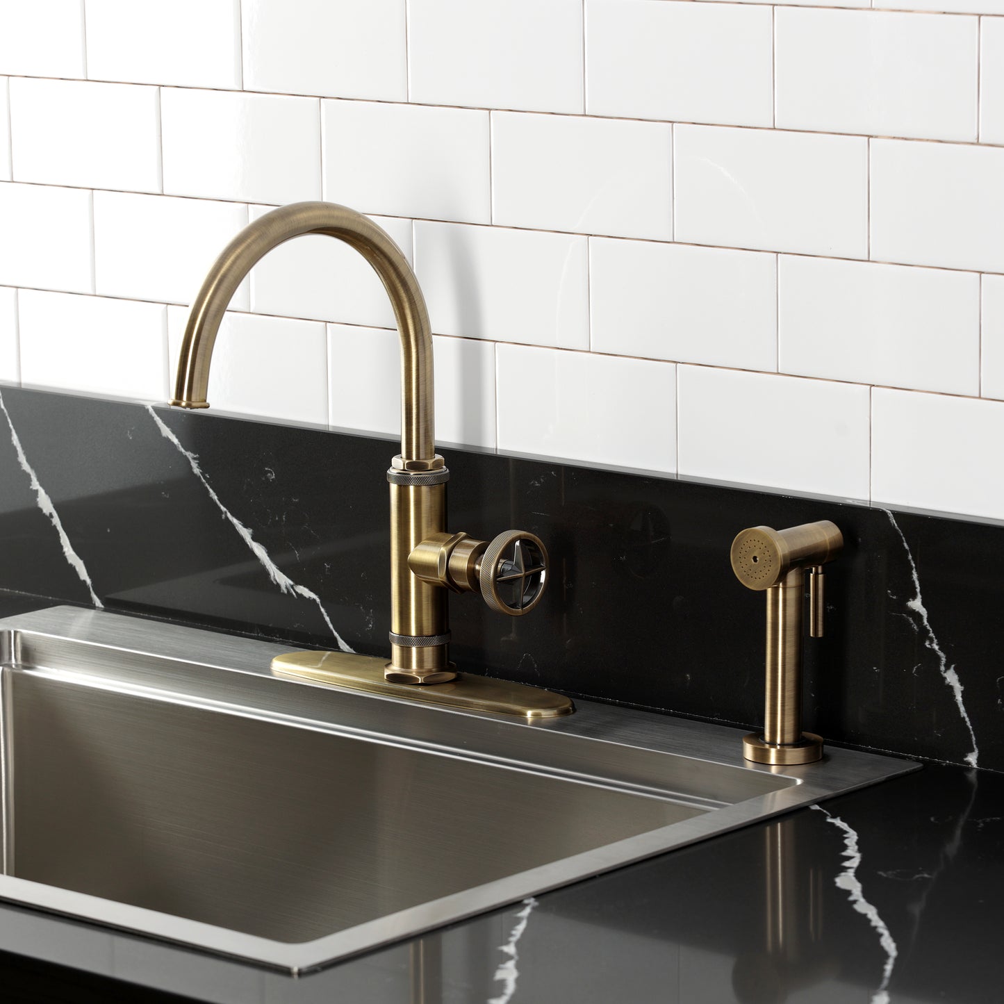 Kingston Brass KSD2433RNX Ostro Single-Handle Kitchen Faucet, Antique Brass with side spray in stylish kitchen setting.