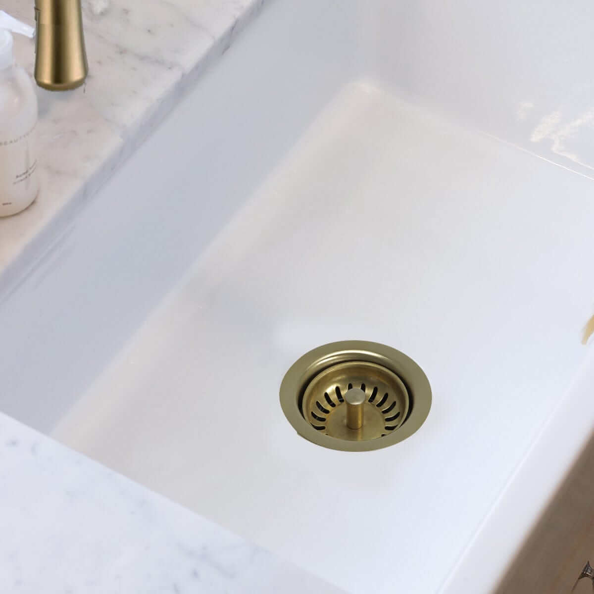 Nantucket Sink 3.5" Extended Flange Disposal Kitchen Drain in Brass - 3.5EDF-PB installed in a fireclay sink.