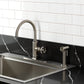 Kingston Brass KSD2433RNX Ostro Single-Handle Kitchen Faucet, Antique Brass with side spray in a modern kitchen.