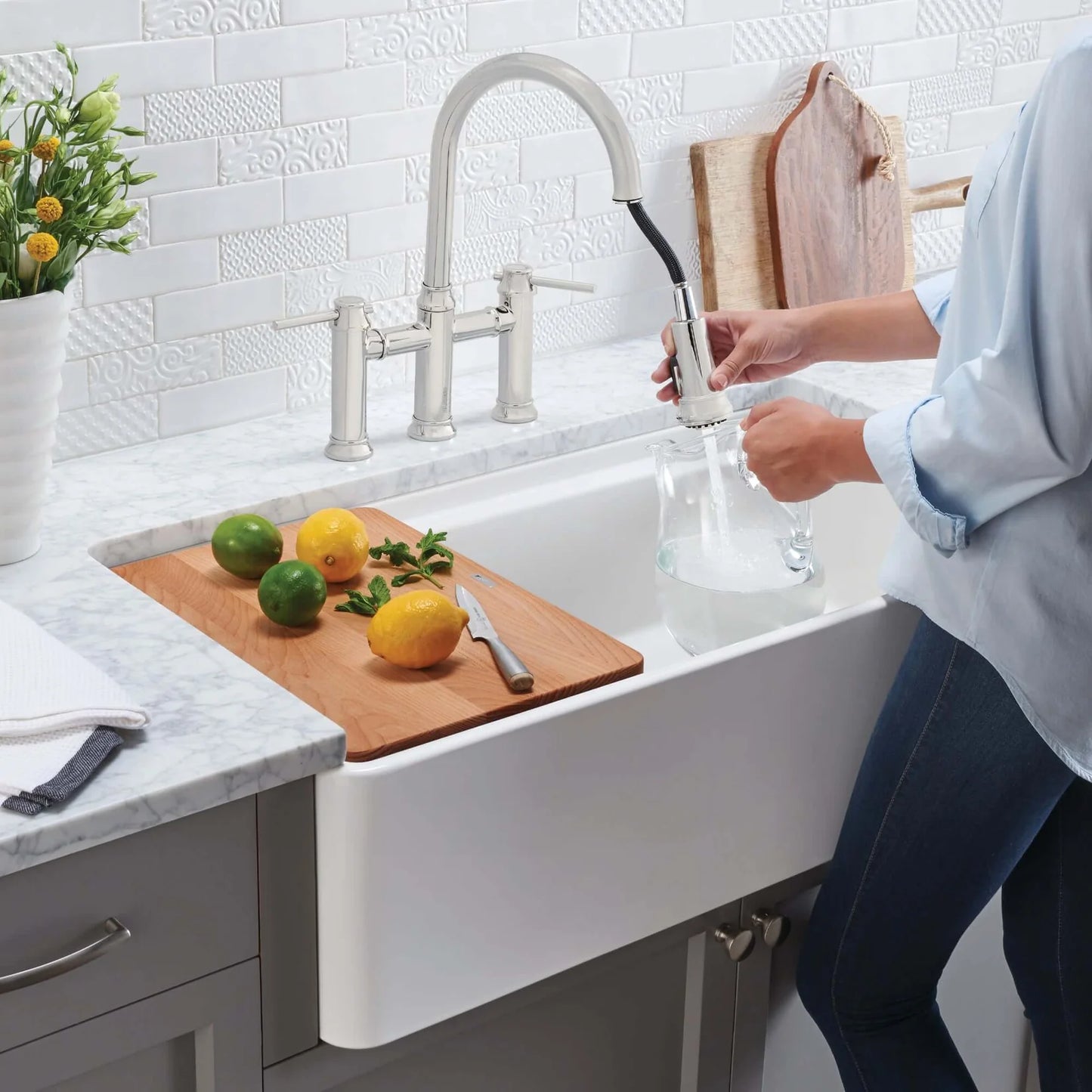 Lifestyle image of woman using Blanco Performa 36" fireclay farmhouse sink and cutting board
