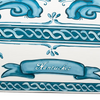 Close up of 33" farmhouse sink with decorative blue design on apron showing detail of the Nantucket brand name