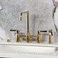 Kingston KS8287CTLBS Continental Bridge Kitchen Faucet with Brass Sprayer, Brushed Brass on marble background.
