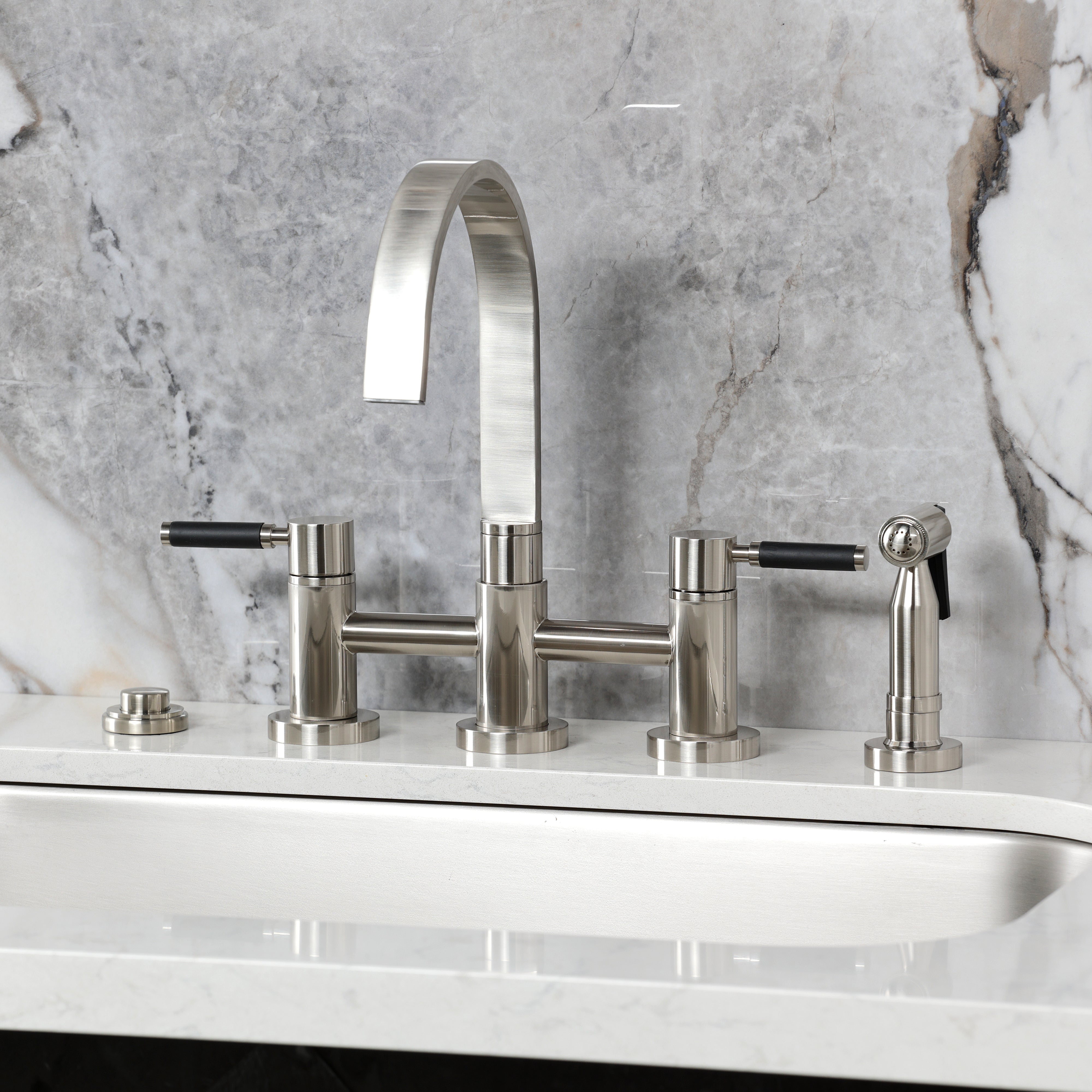 Kingston KS8267DKLBS Kaiser Bridge Kitchen Faucet with Brass Sprayer, Brushed Brass on a sleek countertop.