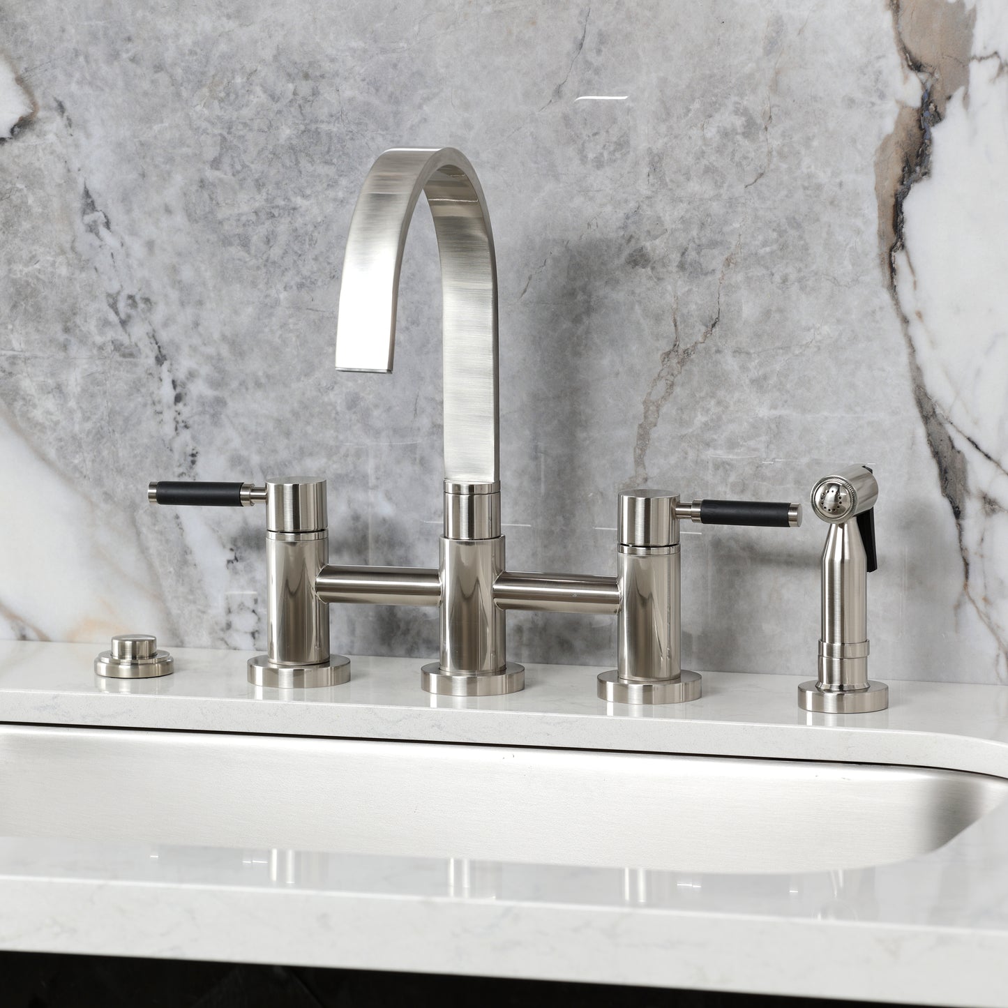 Kingston KS8267DKLBS Kaiser Bridge Kitchen Faucet with Brass Sprayer, Brushed Brass on a sleek countertop.