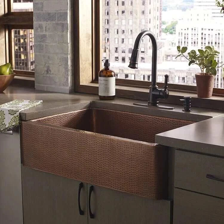 Thompson Quiroga 33" Antique Copper Farmhouse Sink - KSA-3322AH showcased in a modern kitchen with a stylish faucet.