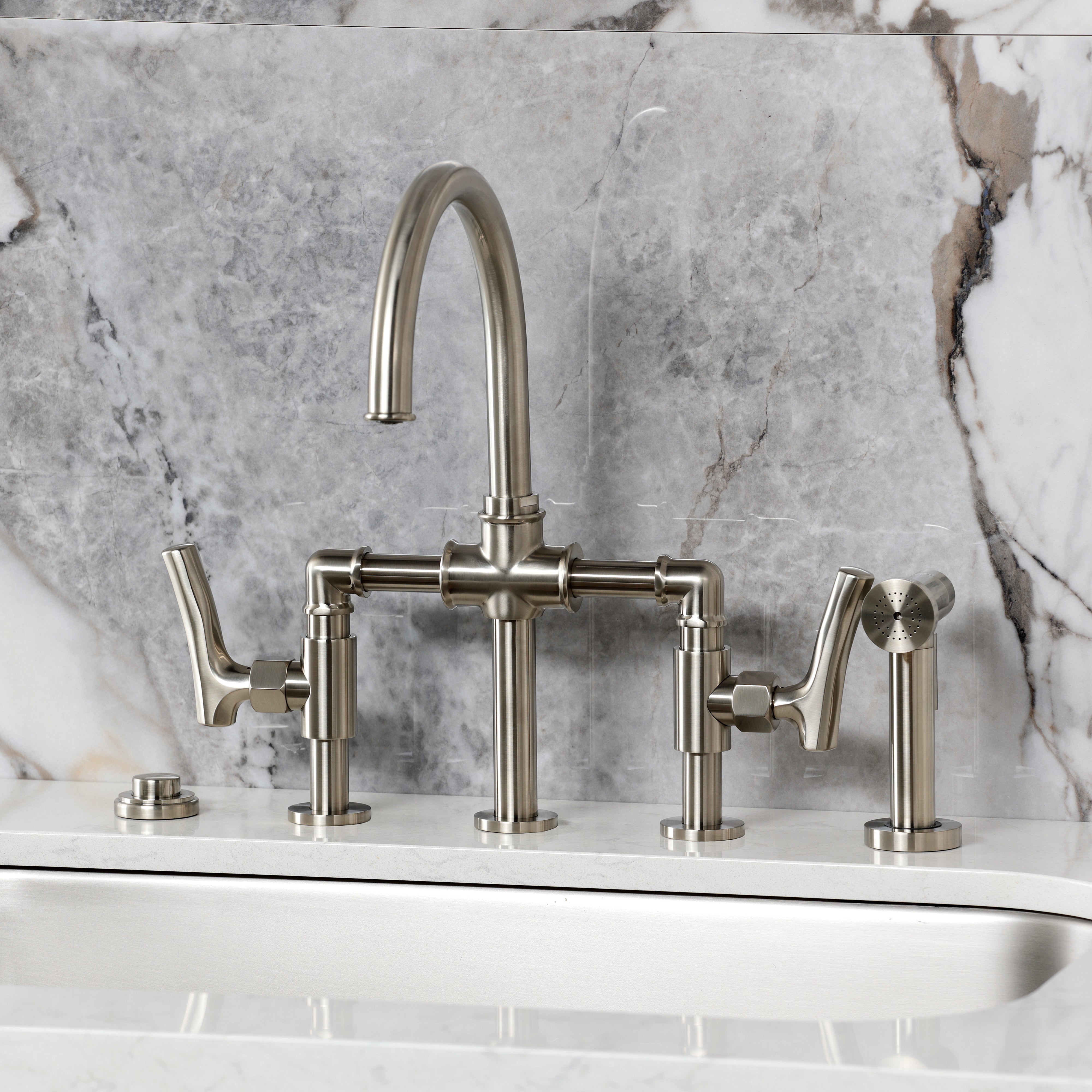 Kingston KS2333TKL Hallerbos Bridge Kitchen Faucet with Brass Sprayer, Antique Brass installed with a marble backdrop.