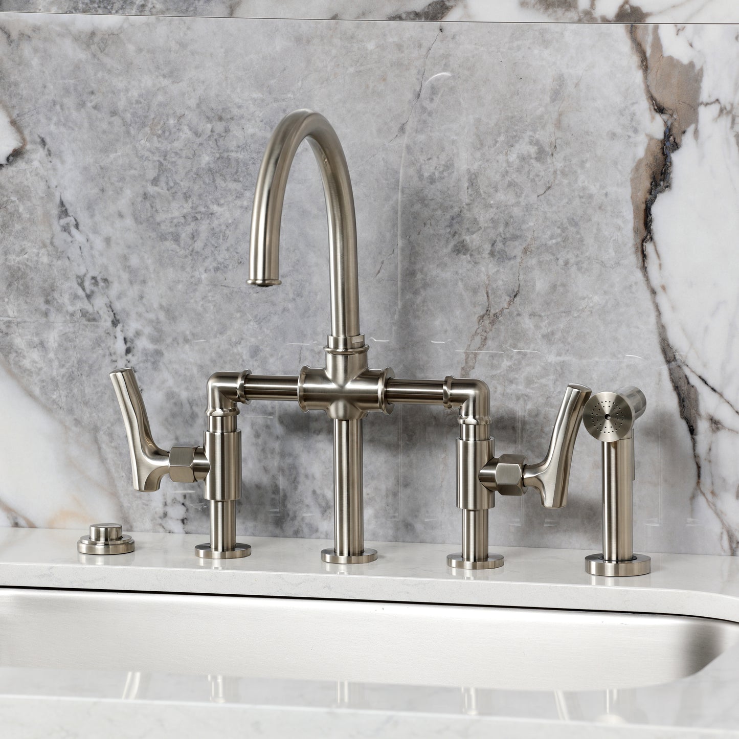 Kingston KS2333TKL Hallerbos Bridge Kitchen Faucet with Brass Sprayer, Antique Brass installed with a marble backdrop.