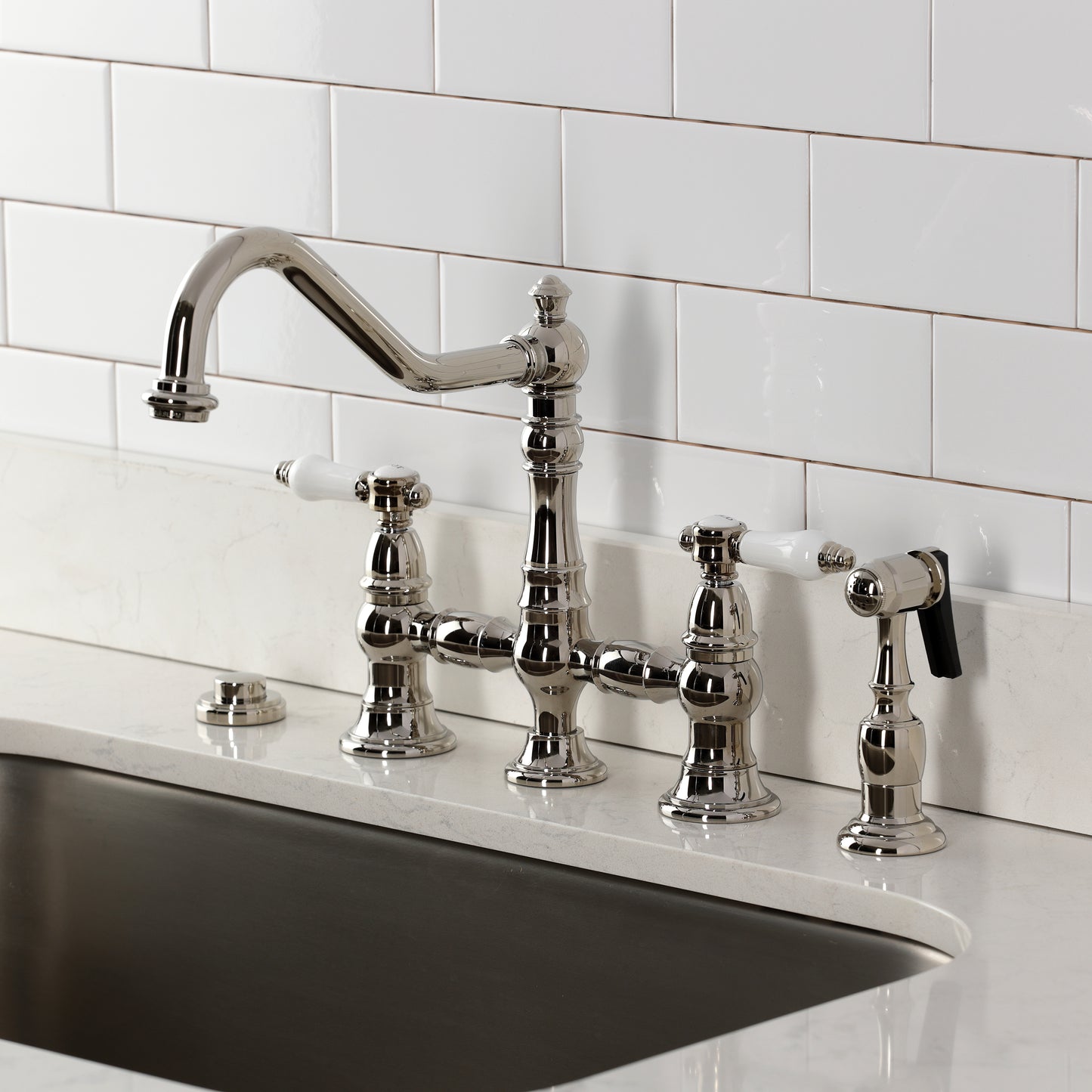 Kingston KS3277BPLBS Bel-Air Bridge Kitchen Faucet with Brass Sprayer, Brushed Brass installed in a sleek kitchen.