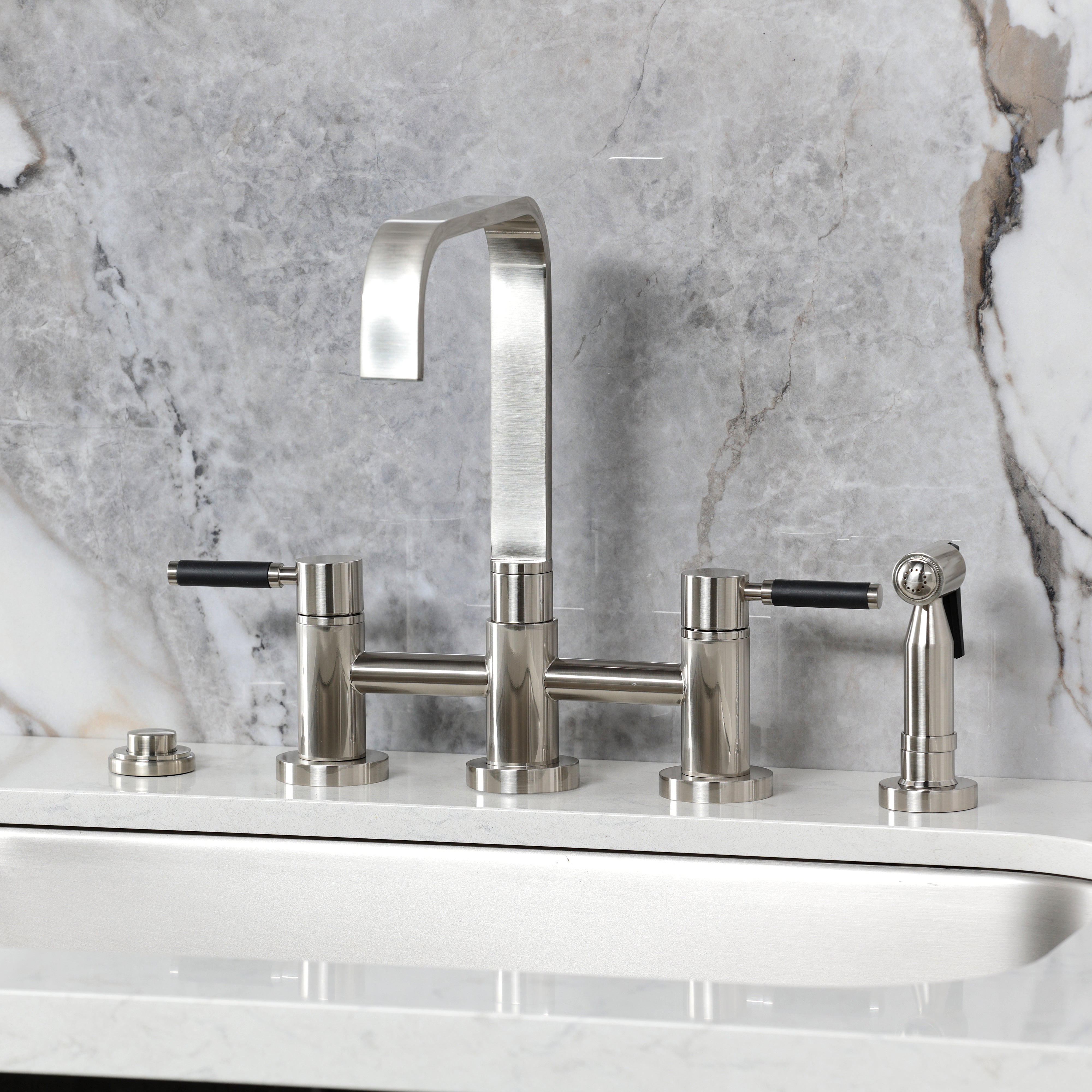 Kingston KS8257DKLBS Kaiser Bridge Kitchen Faucet with Brass Sprayer, Brushed Brass on a stylish countertop.