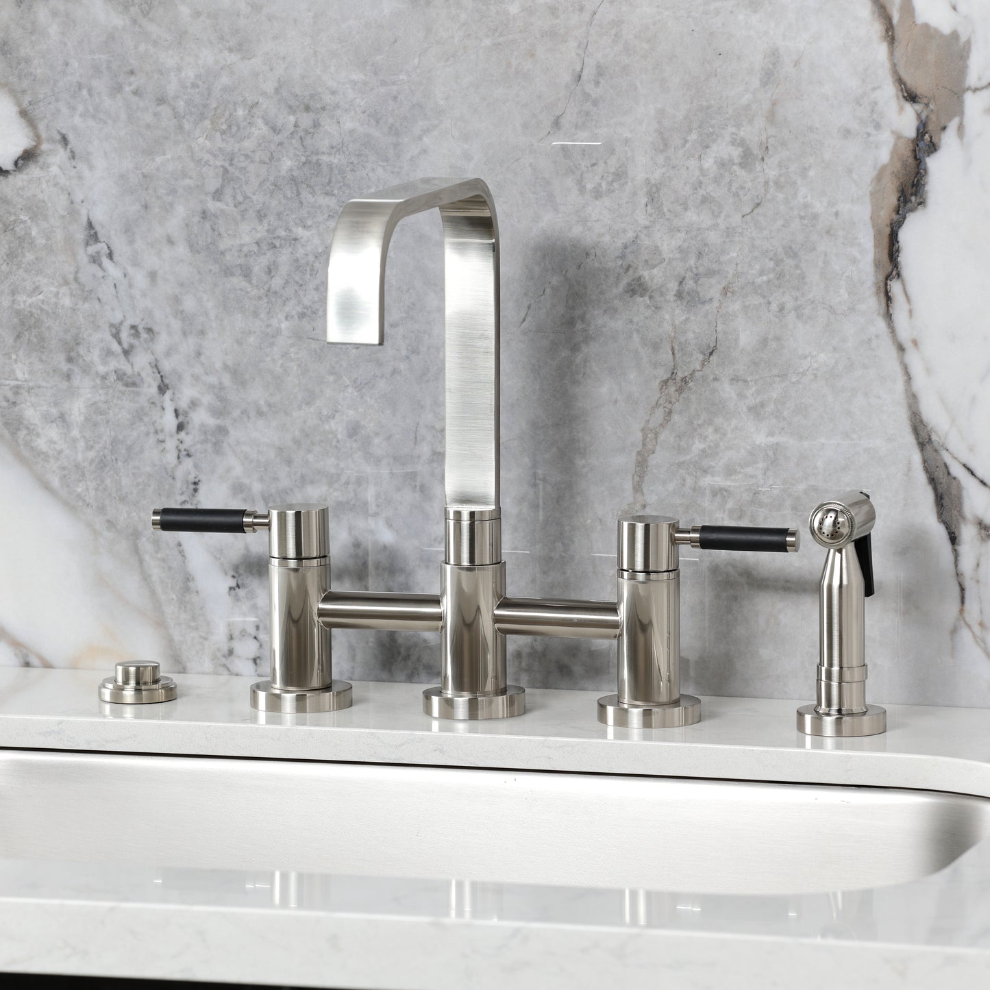 Kingston KS8257DKLBS Kaiser Bridge Kitchen Faucet with Brass Sprayer, Brushed Brass on a stylish countertop.