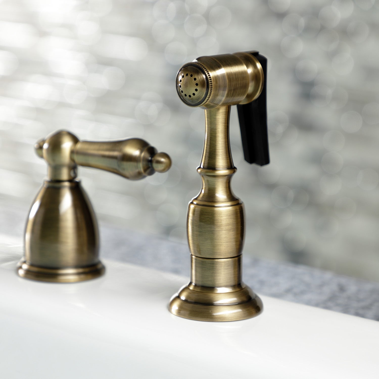 Kingston Brass "Antique Brass" widespread kitchen faucet  with spray head accessory on a blurred background