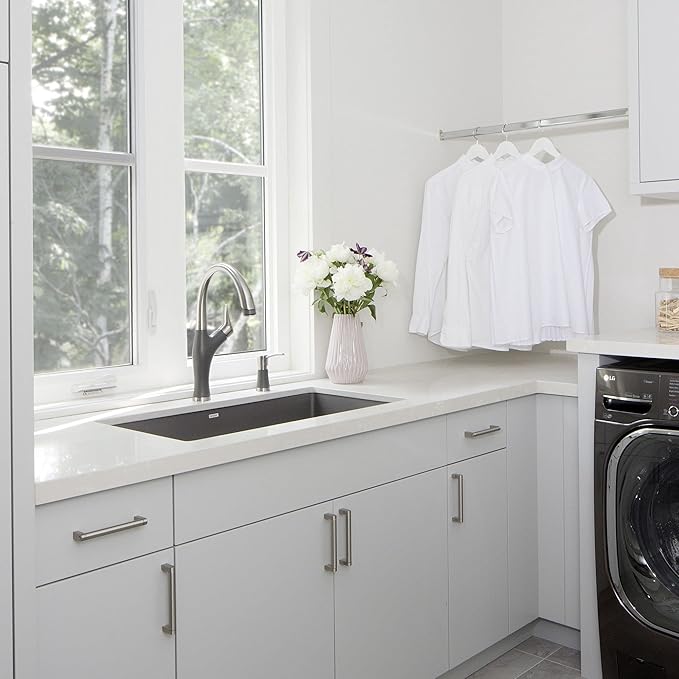 Modern laundry room with white cabinets, Blanco Silgranit Super Single 32"  kitchen sink in Metallic Gray and washing machine.