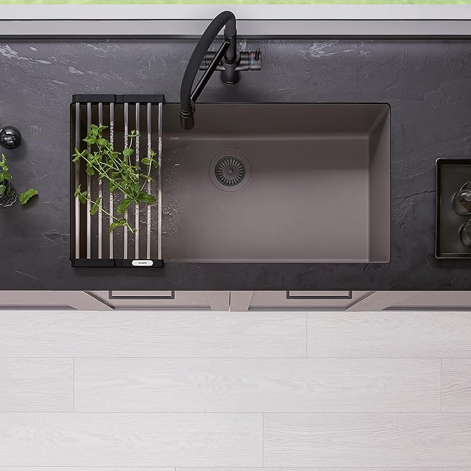 Blanco Silgranit Super Single 32"  kitchen sink in Volcano Gray with a black faucet and an optional drain rack with herbs on a dark countertop.