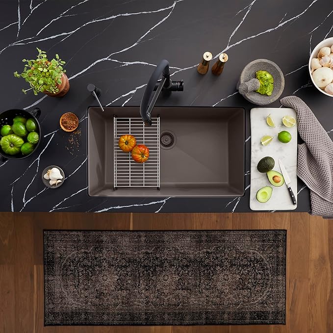 Kitchen counter with a Blanco Silgranit Super Single 32"  kitchen sink in Volcano Gray, optional accessories, and various kitchen items on a dark marble countertop.