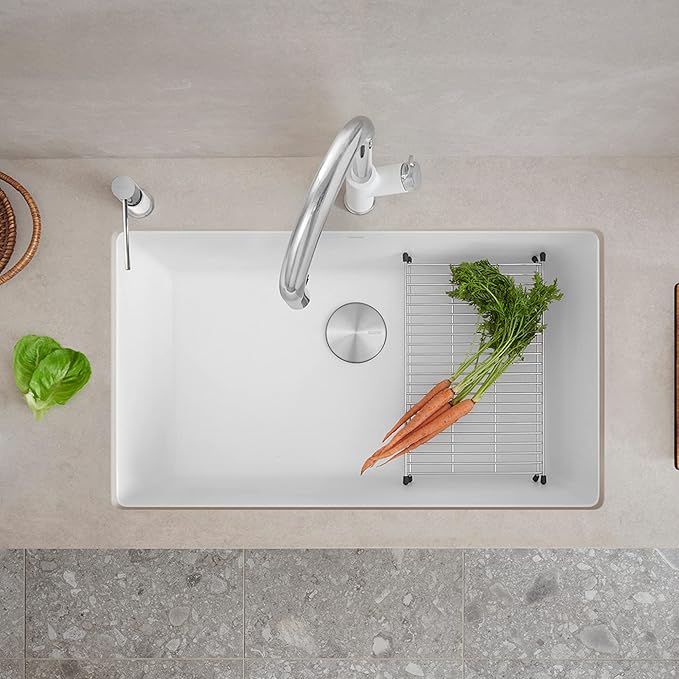 White Blanco Precis 32" Silgranit kitchen sink with a grid and vegetables on a light-colored countertop.