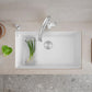 Modern white Blanco Precis 32" Silgranit kitchen sink with silver faucet and vegetables on a light gray countertop.