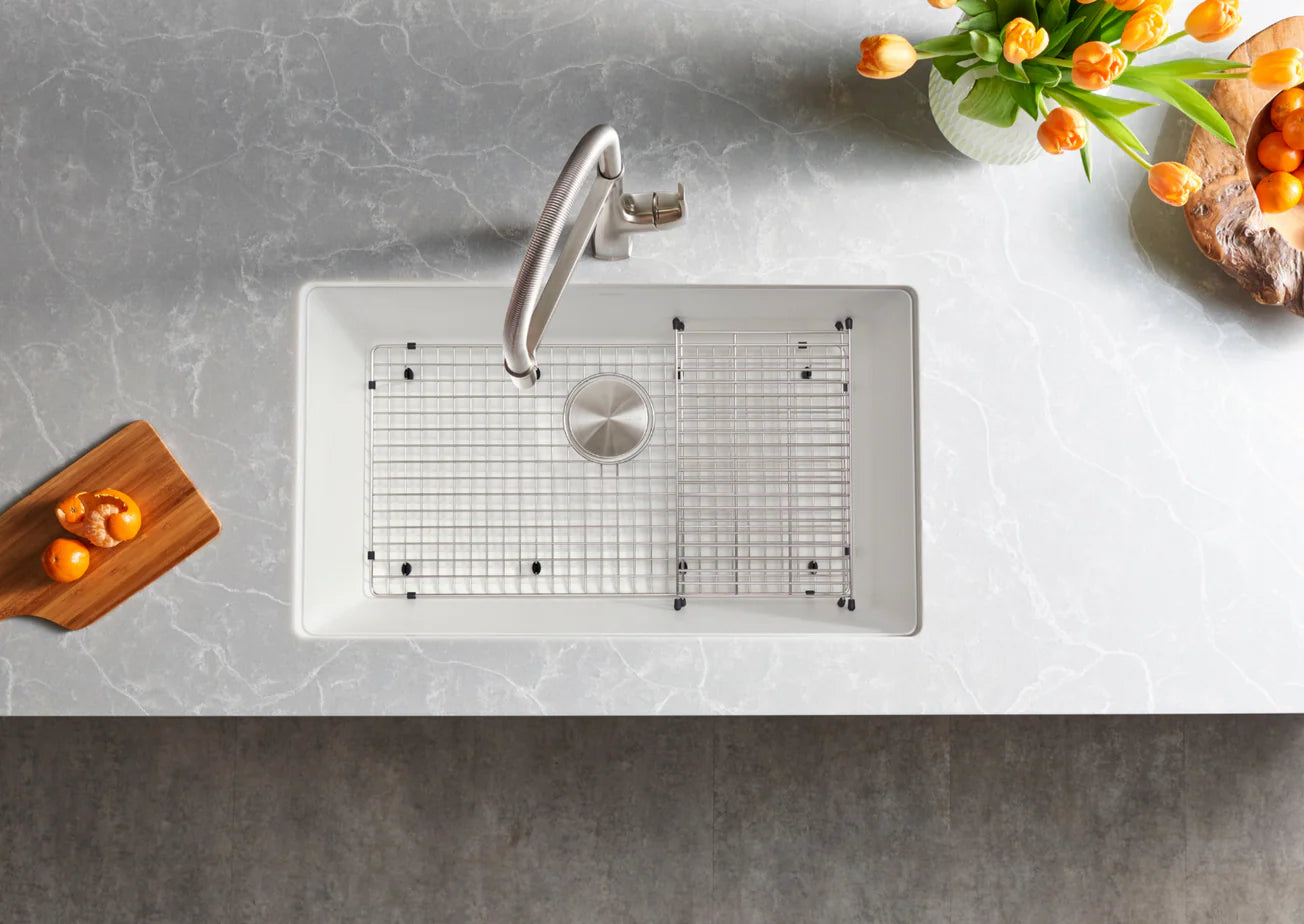 White White Blanco Precis 32" Silgranit kitchen sink with grid on a gray countertop, surrounded by decorative elements.