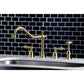 Kingston Brass "Brushed Brass" widespread kitchen faucet set on a sink with a black tiled wall background
