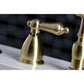 Kingston Brass "Burshed Brass" widespread kitchen faucet  handles on a white sink with a blurred black and white checkered background