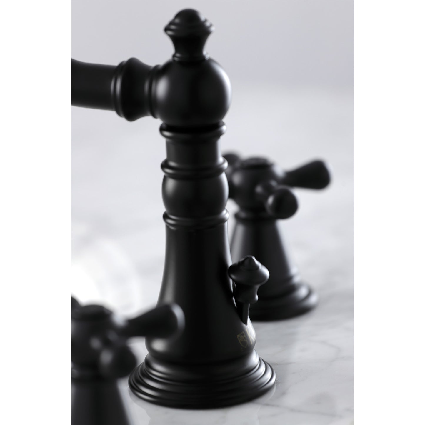 Close-up view of KINGSTON Brass Widespread Bathroom Faucet with Pop-Up Drain - FSC1979AAX showcasing intricate Victorian design details.
