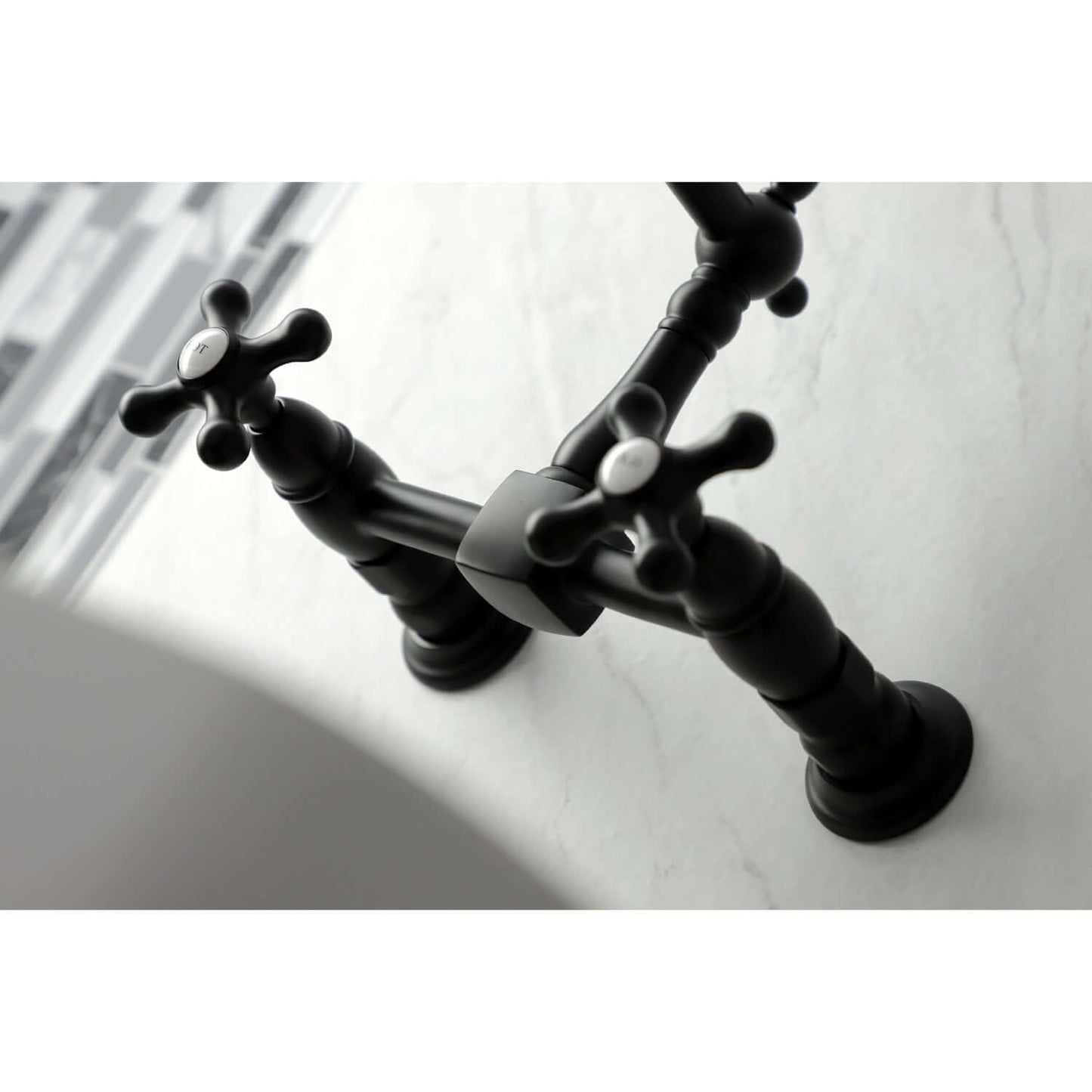 Kingston Brass matte black double-handle 2-hole wall-mount bridge kitchen faucet on a white sink with blurred background