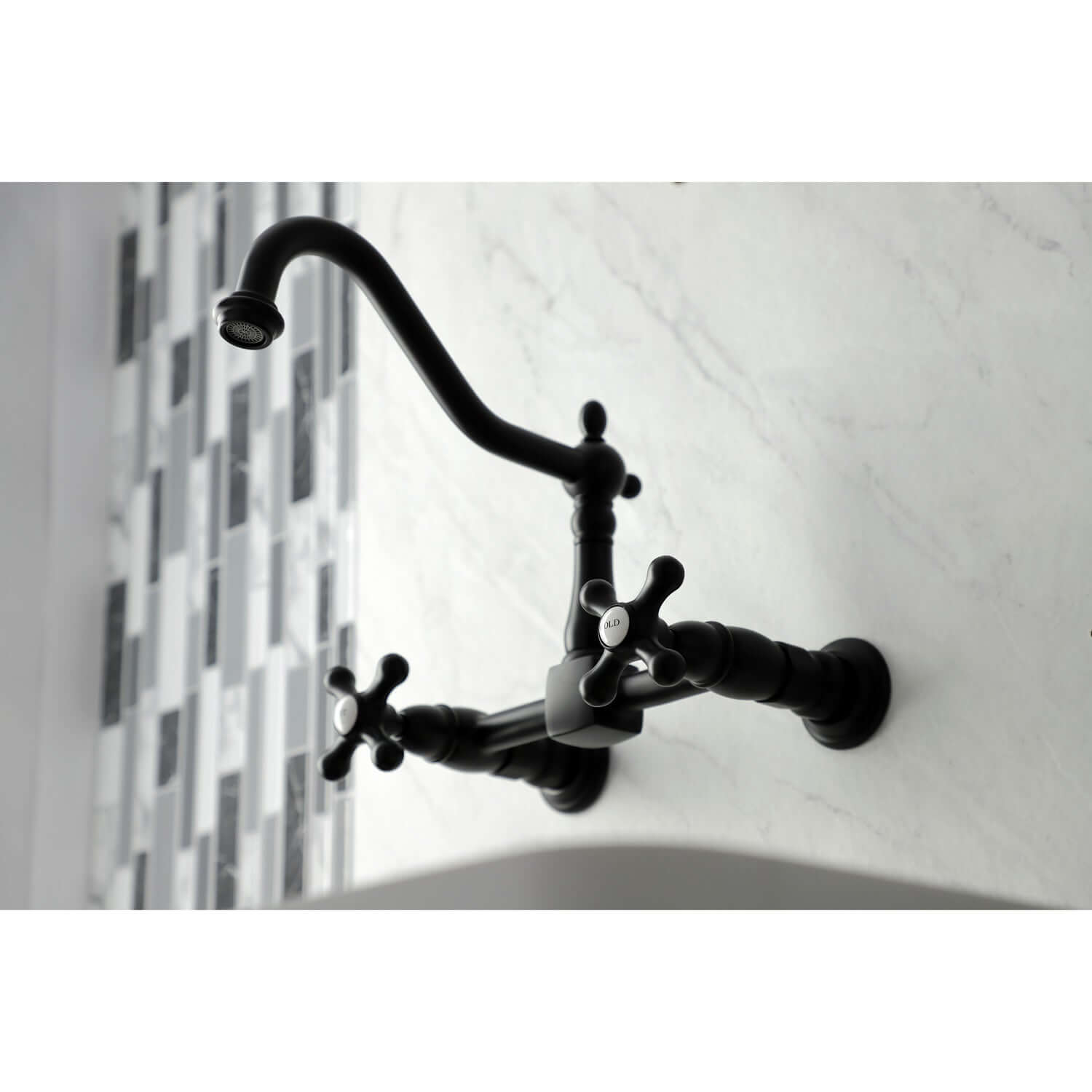Kingston Brass matte black double-handle 2-hole wall-mount bridge kitchen faucet on a white wall with a tiled backsplash.