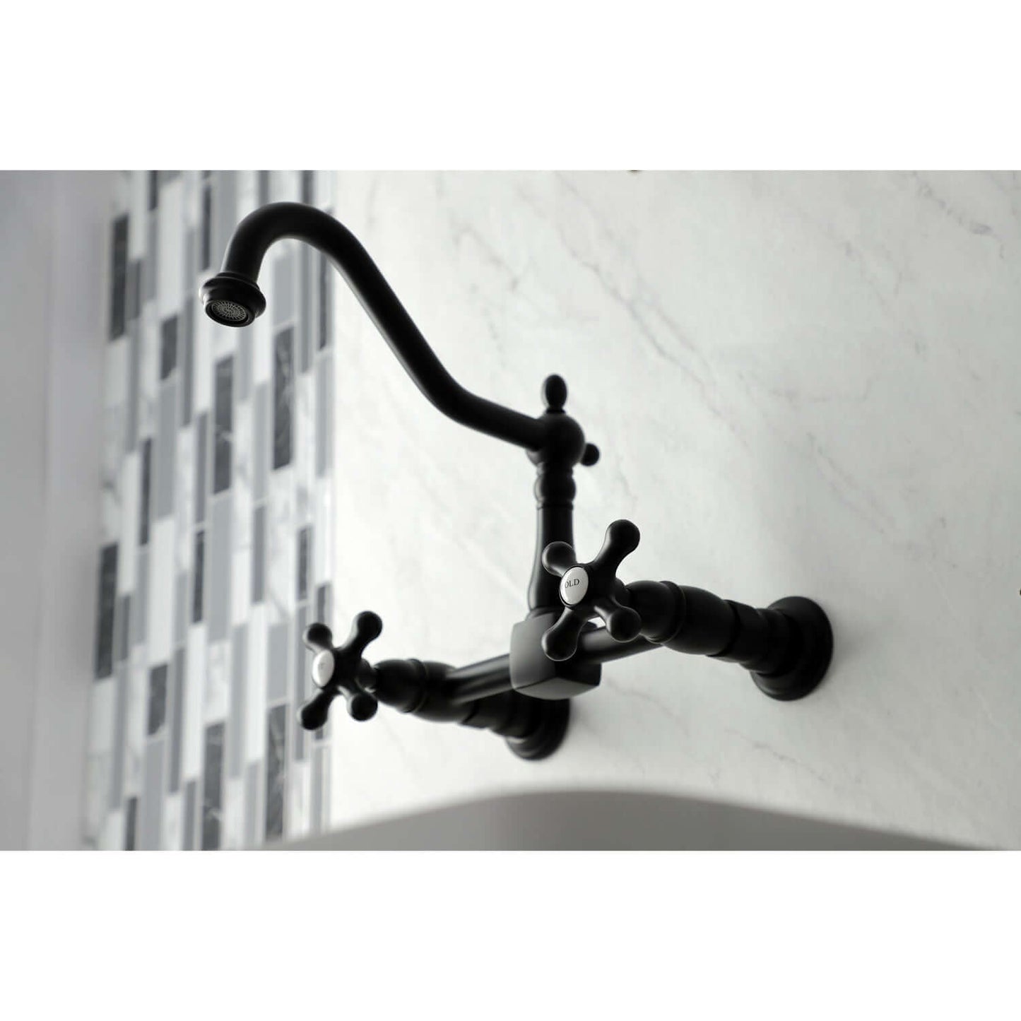 Kingston Brass matte black double-handle 2-hole wall-mount bridge kitchen faucet on a white wall with a tiled backsplash.