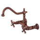 Vintage-style Kingston Brass antique copper double-handle 2-hole wall-mount bridge kitchen faucet on a white background
